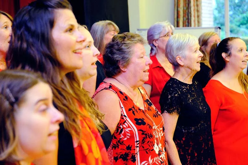 The front row of women singers viewed from the left hand side
